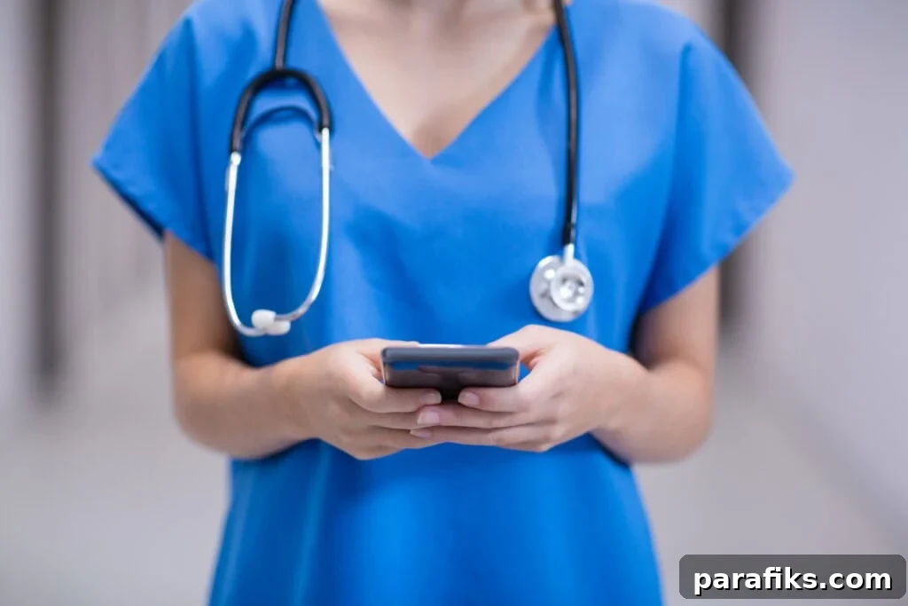 24 Jobs AI Won’t Replace That Still Need Human Skills 2 Mid section of female health care worker using mobile phone in corridor of hospital