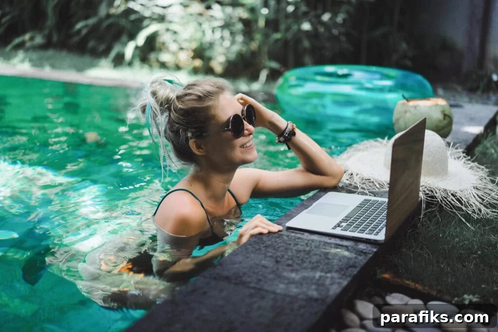 person working on laptop while in pool