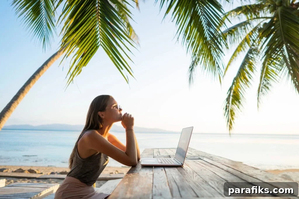 person working on laptop on the beach